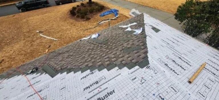 Alt text: A partially completed roof shows shingles being installed over underlayment. Some shingles are misaligned, with construction tools nearby on the rooftop.