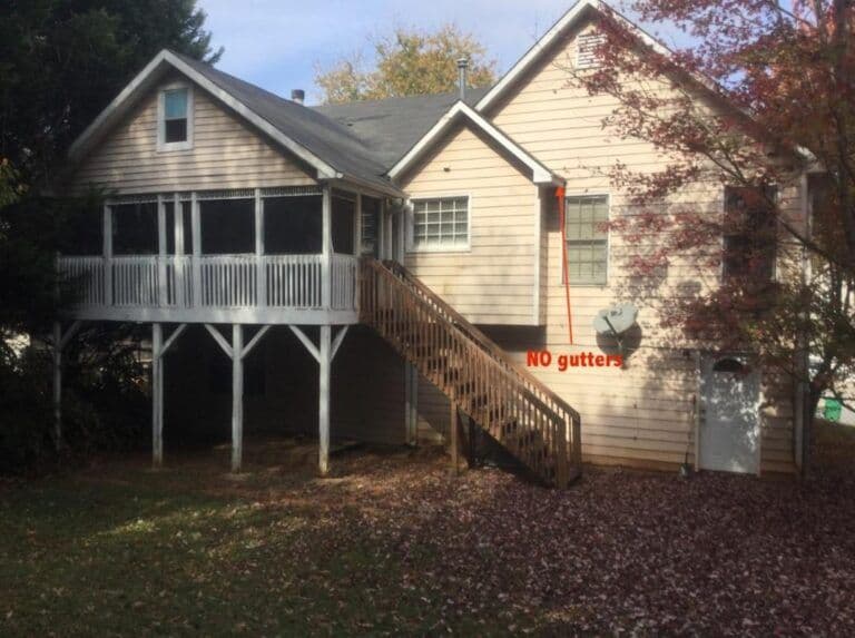 A beige house with a raised screened porch and wooden stairs. Text in red reads "NO gutters." Fallen leaves cover the lawn, trees nearby.